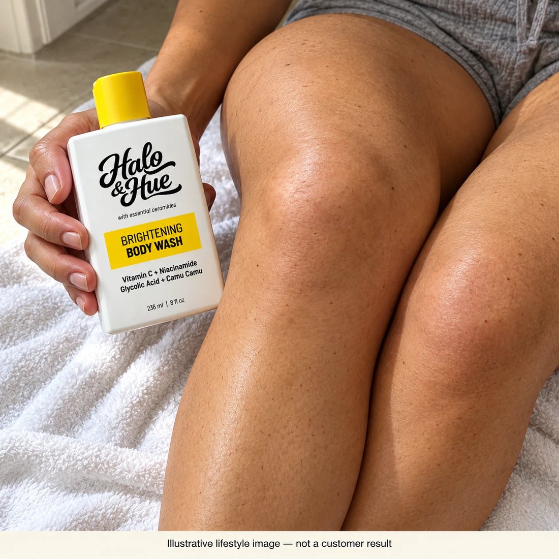 Holding the Brightening Body Wash next to knees after a shower